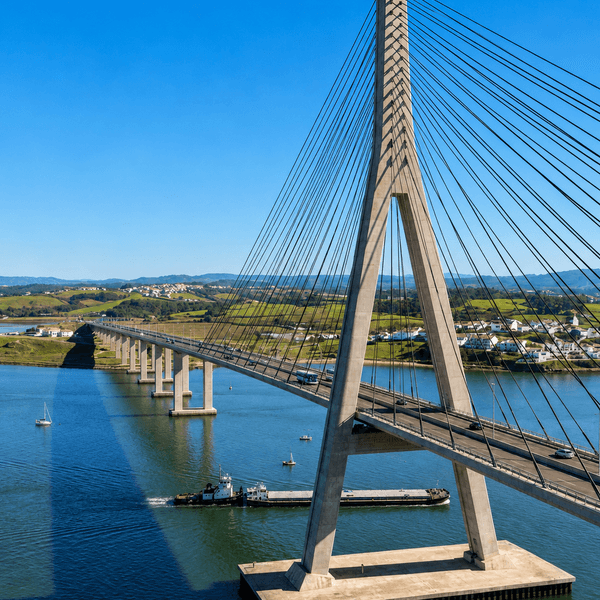 Cable-stayed bridge with concrete pylons spanning a river during construction